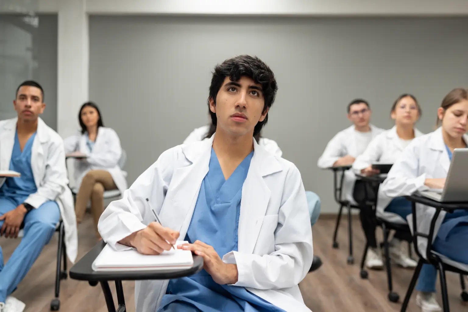Medical students attentively listening in classroom.