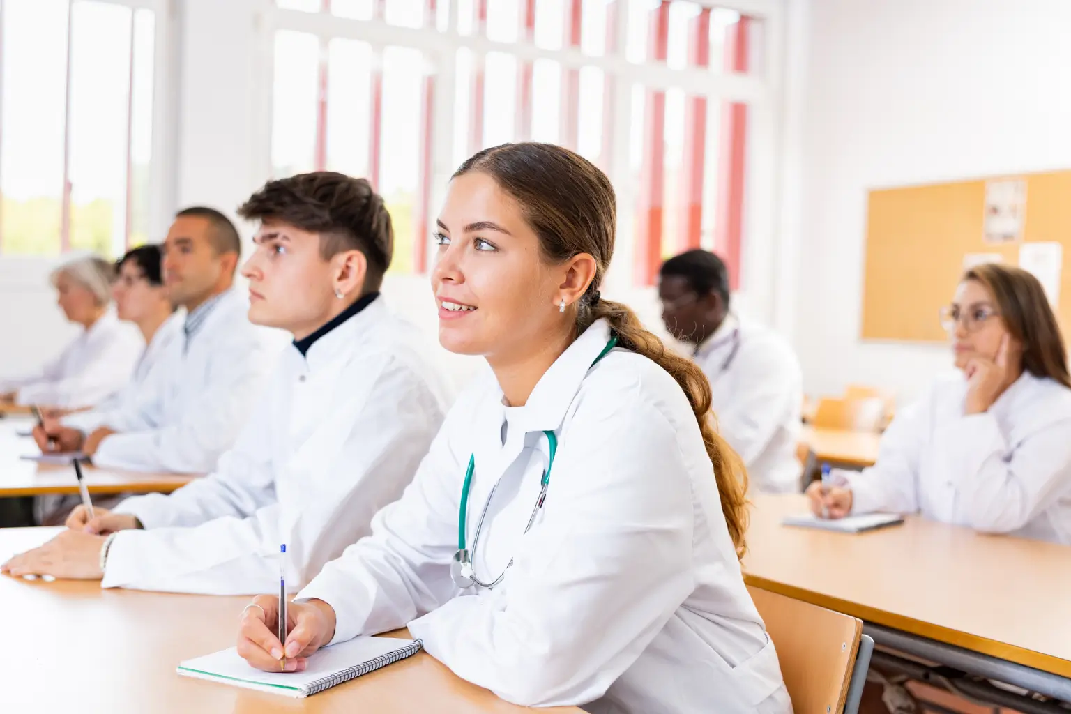 Medical students attentively listening in classroom.