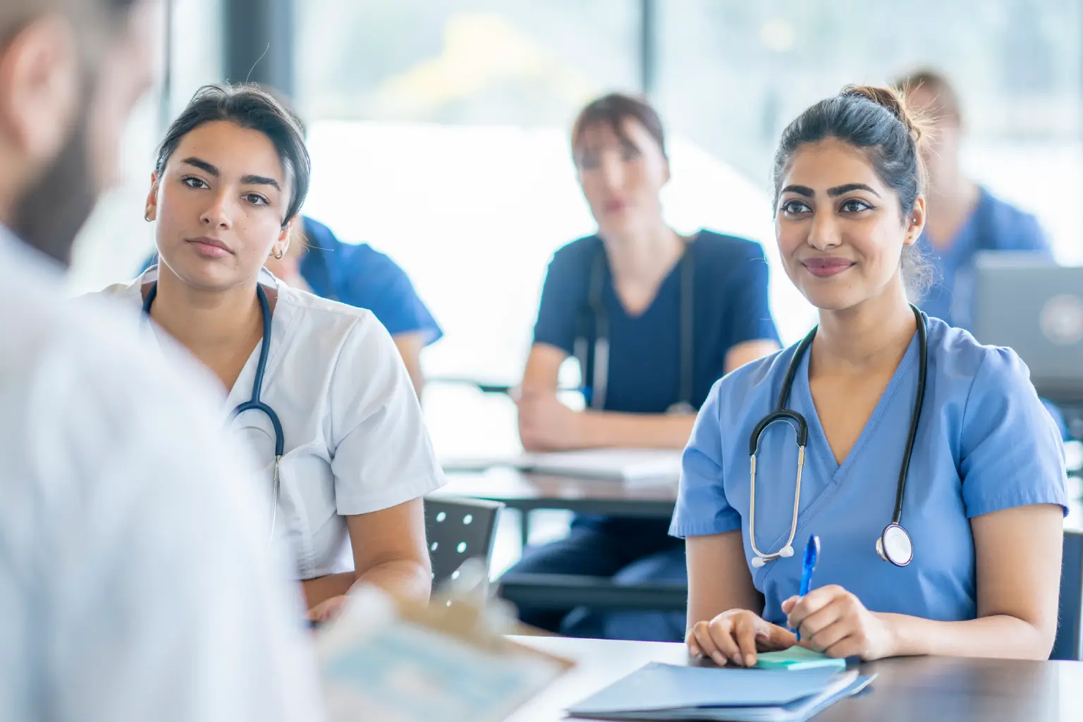Medical students attentively listening in class.