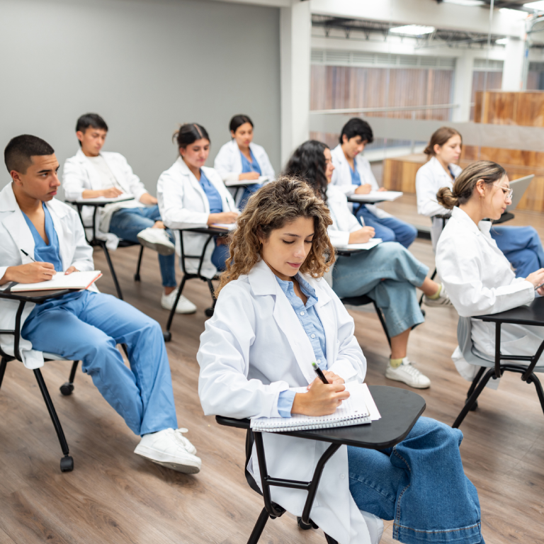 Medical students taking notes in classroom.