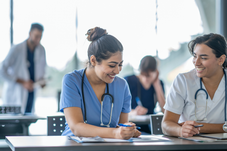 Healthcare professionals studying together in classroom.