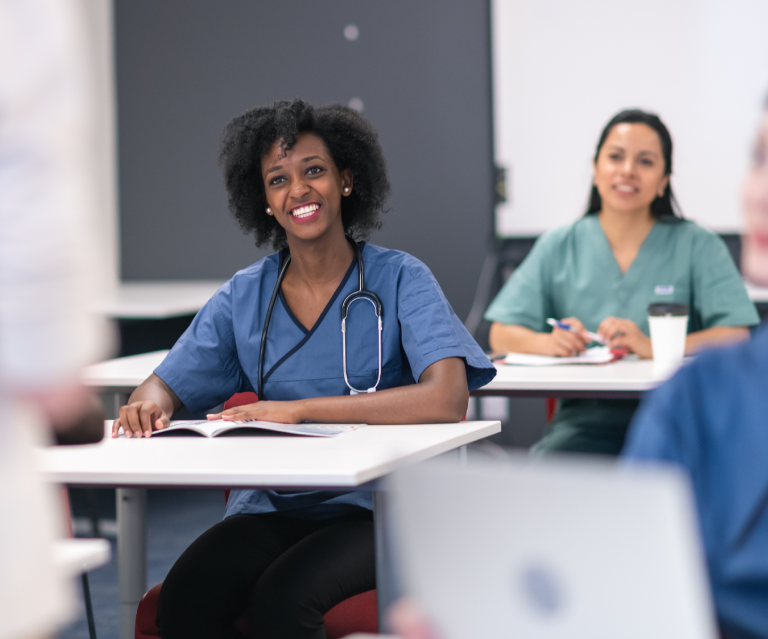 Medical students attentively listening in classroom.