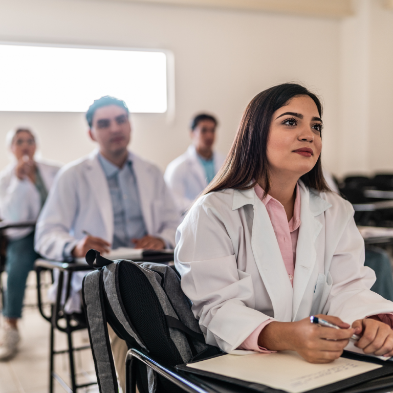 Medical students attentively listening in classroom.