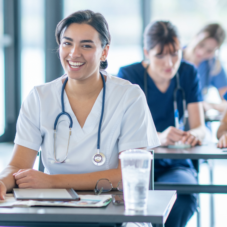 Smiling medical professional in a classroom setting.
