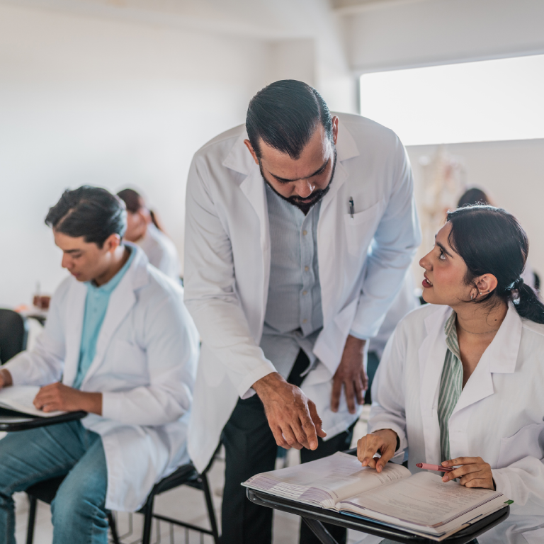 Medical professionals discussing notes in classroom.