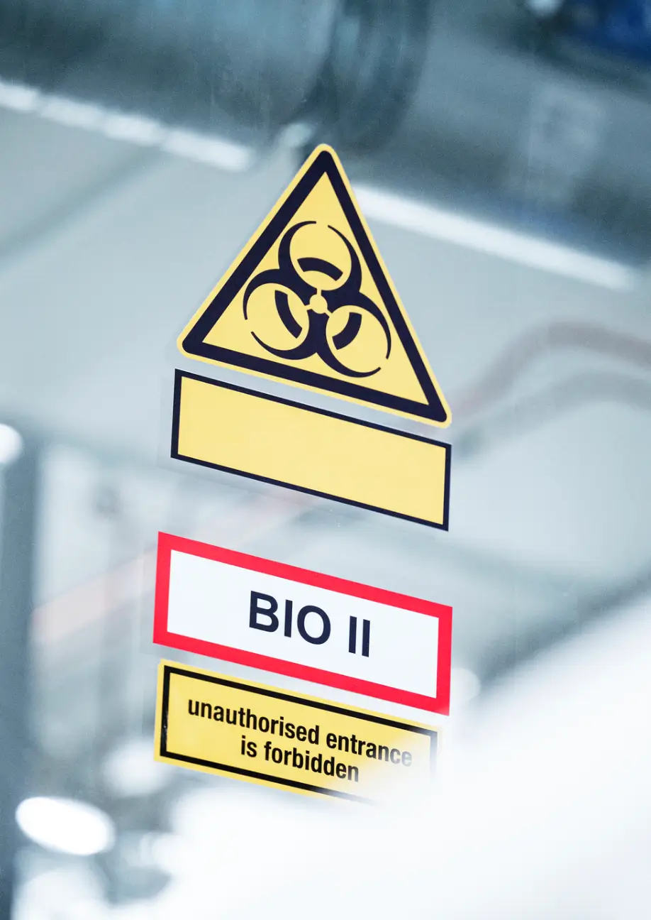 Biohazard warning sign on glass door.