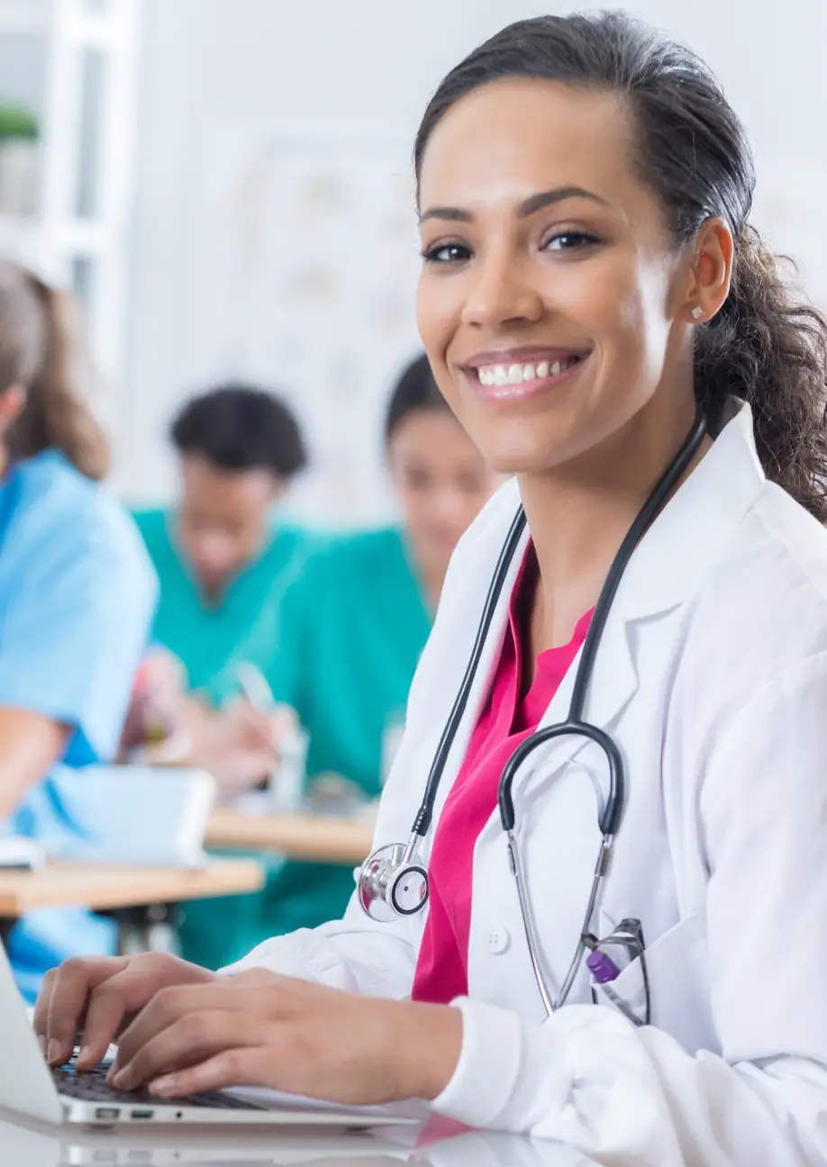 Smiling doctor with stethoscope and colleagues.