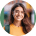 Smiling person with long hair, blurred background.