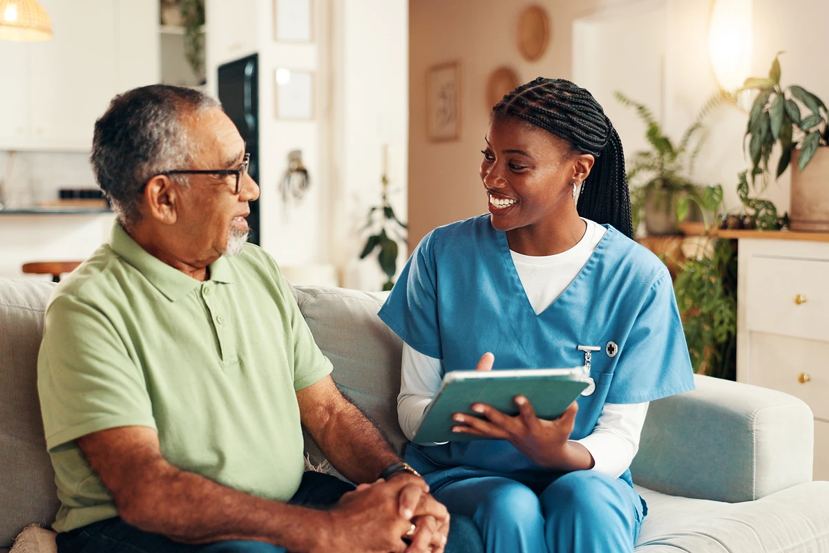 Healthcare worker consulting with elderly man.